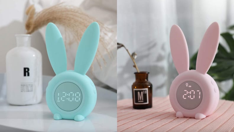 Hasenohren-Wecker auf rosa Decke.