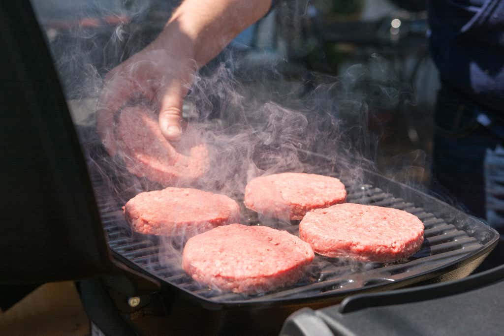 Burger patties being placed on a Weber Q 1200.
